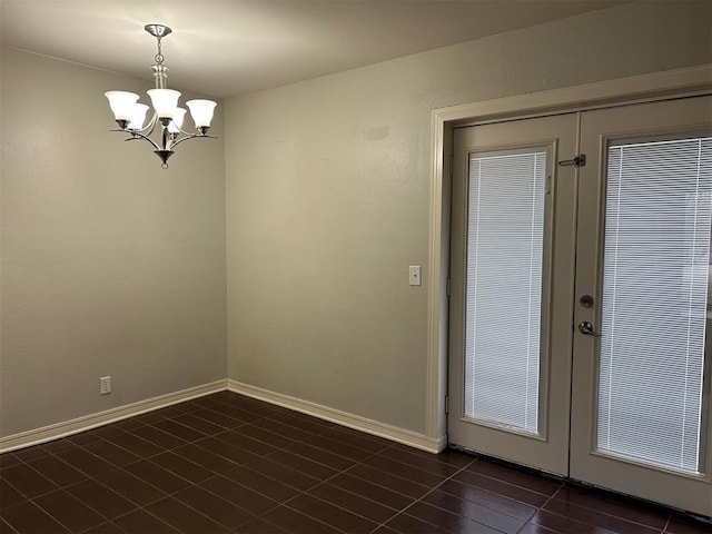 interior space featuring a chandelier, french doors, and baseboards