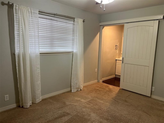 unfurnished bedroom with carpet, baseboards, and connected bathroom