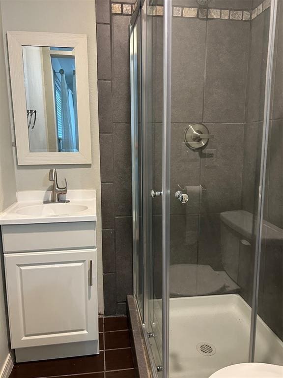 full bath featuring a stall shower, vanity, and toilet