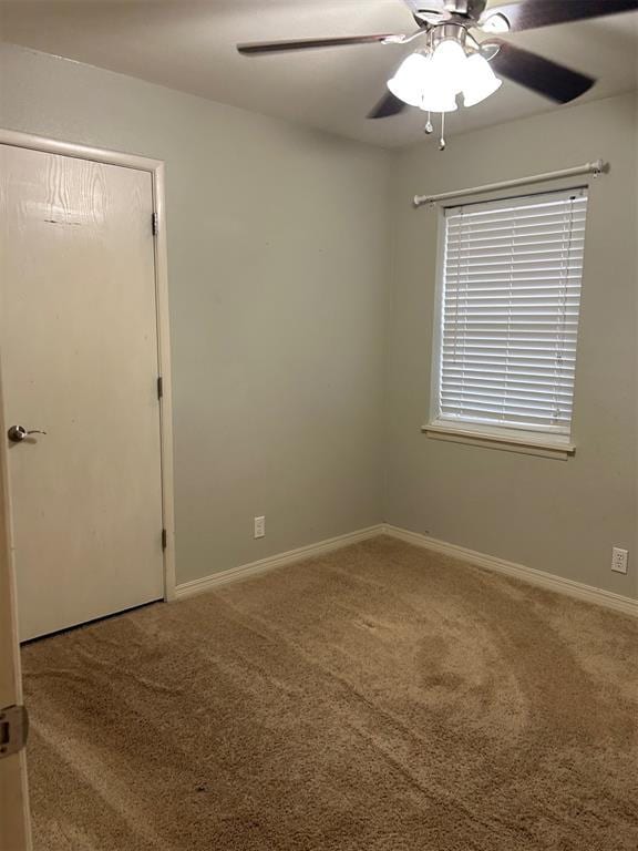 spare room with carpet, baseboards, and ceiling fan