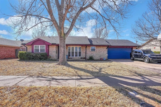 ranch-style house with driveway, roof with shingles, a garage, and brick siding