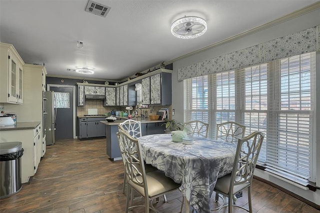 dining room with ornamental molding, dark wood finished floors, and visible vents