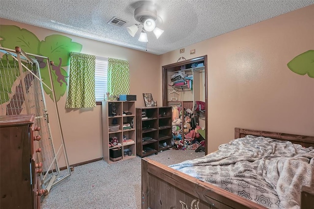 bedroom with carpet floors, a closet, visible vents, ceiling fan, and a textured ceiling