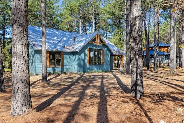 view of front of house with dirt driveway and metal roof