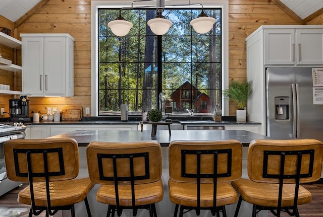 kitchen featuring vaulted ceiling, wooden walls, and open shelves