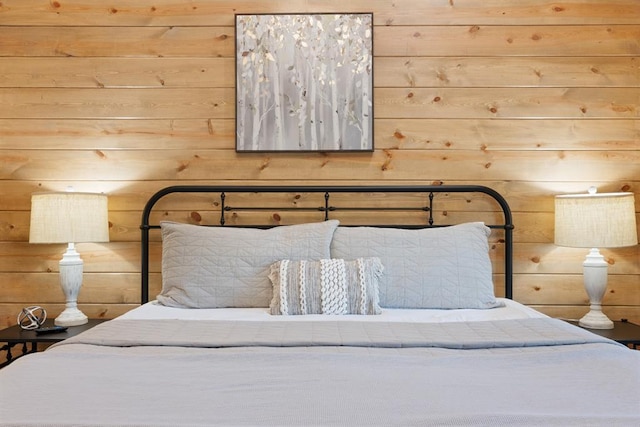 bedroom featuring wooden walls