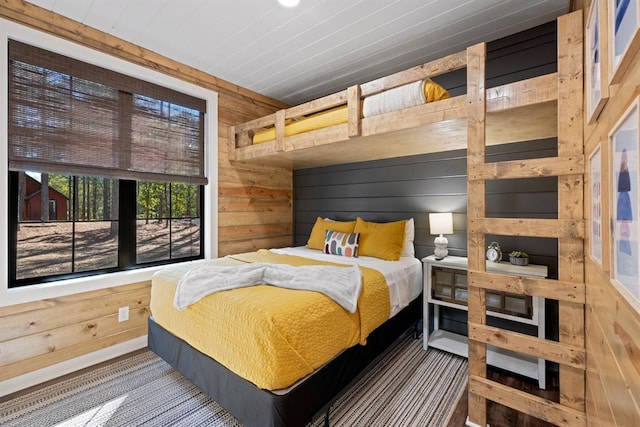 bedroom with wood ceiling and wooden walls