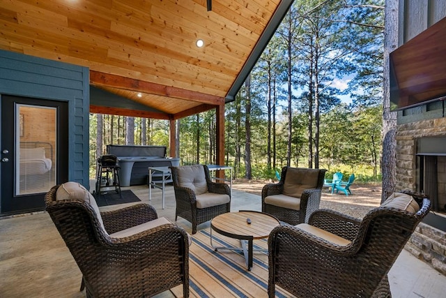 exterior space featuring lofted ceiling, wood ceiling, and an outdoor stone fireplace