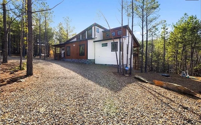 view of property exterior featuring driveway and crawl space