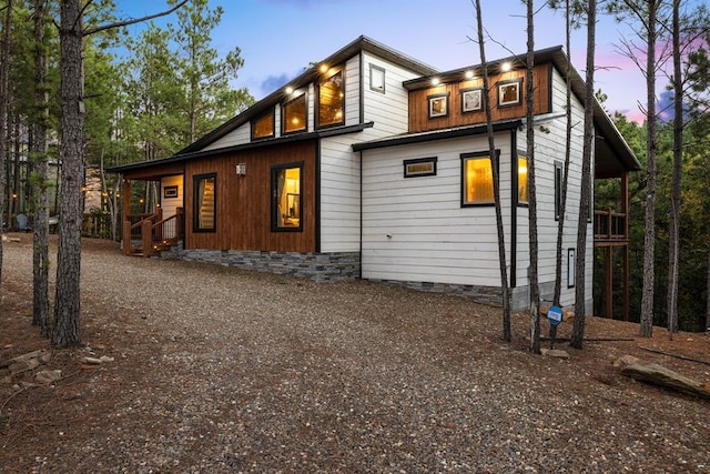 back of property featuring crawl space and dirt driveway