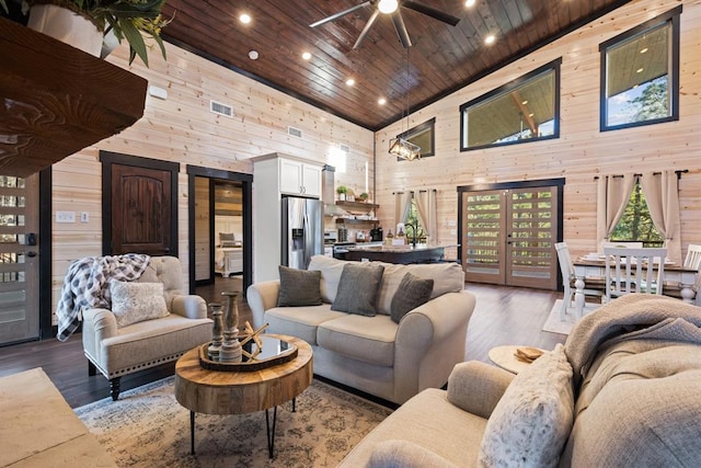 living area with wooden walls, wood finished floors, high vaulted ceiling, recessed lighting, and wood ceiling