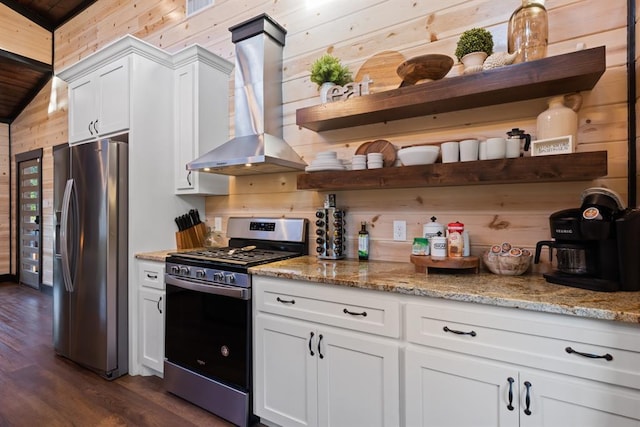 kitchen featuring wooden walls, stainless steel appliances, wall chimney range hood, and open shelves