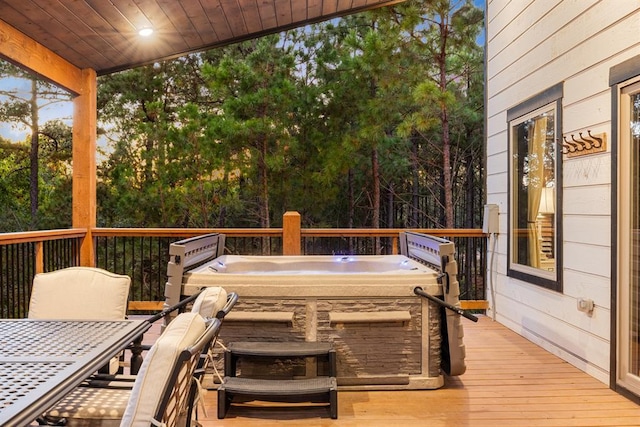 wooden deck with outdoor dining space and a hot tub