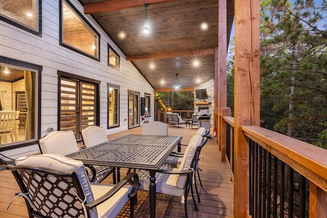 wooden deck featuring outdoor dining area and ceiling fan