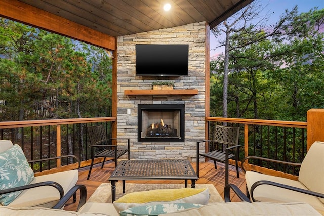 wooden terrace with an outdoor living space with a fireplace