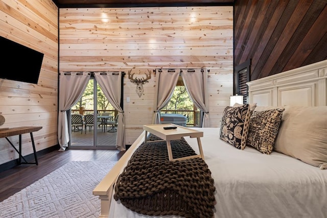 bedroom with access to outside, wooden walls, and wood finished floors