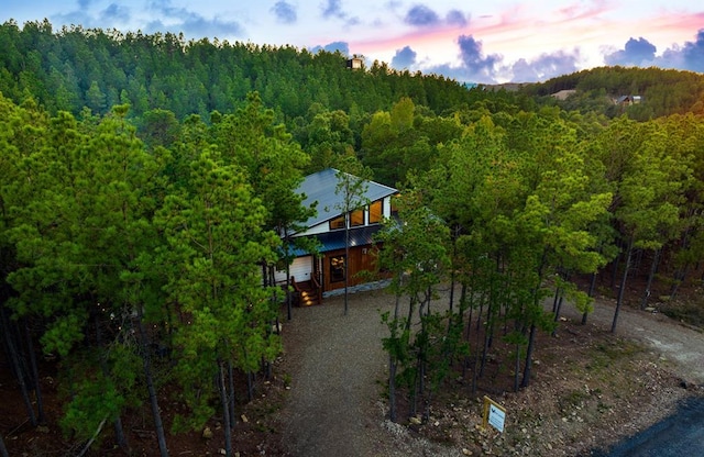 aerial view at dusk with a wooded view