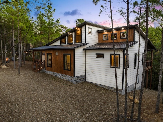 back of property with crawl space, driveway, and metal roof