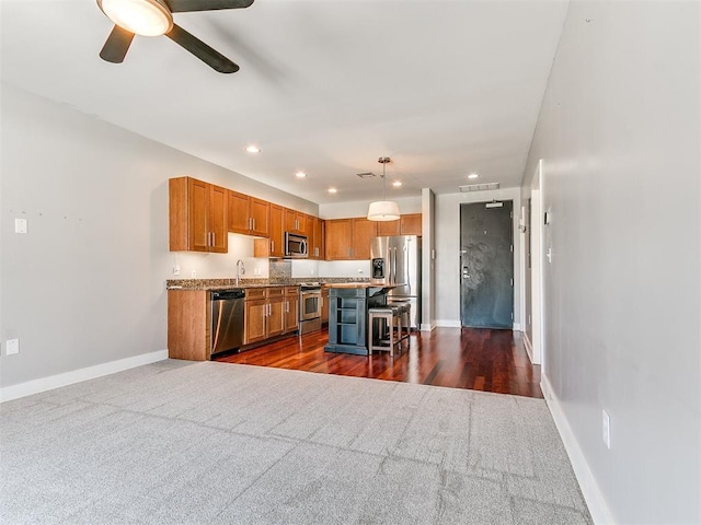 444 N Central Ave Unit 110, Oklahoma City, OK 73104 - kitchen featuring stainless steel appliances, dark carpet, a kitchen bar, baseboards, and recessed lighting