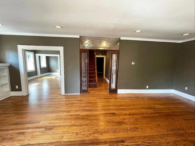 unfurnished room featuring recessed lighting, crown molding, baseboards, and wood finished floors