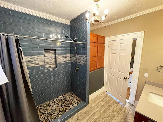 bathroom featuring ornamental molding, tiled shower, vanity, and wood finished floors