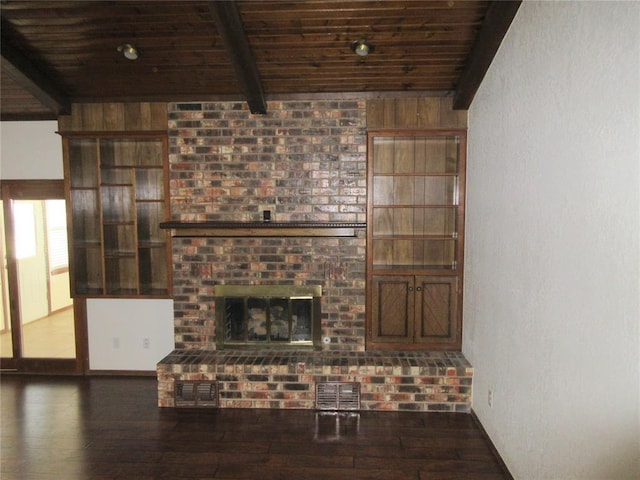 unfurnished living room featuring beamed ceiling, a fireplace, wood finished floors, and wood ceiling