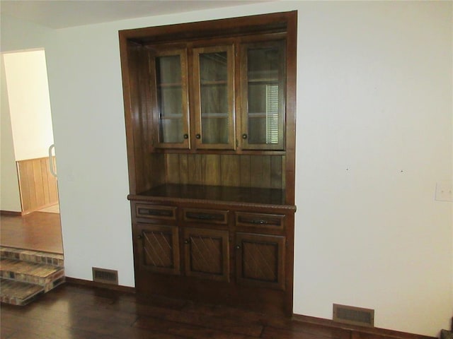 interior details featuring baseboards, visible vents, and wood finished floors