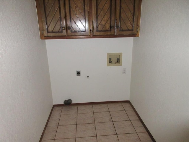 clothes washing area featuring cabinet space, baseboards, hookup for an electric dryer, washer hookup, and light tile patterned flooring