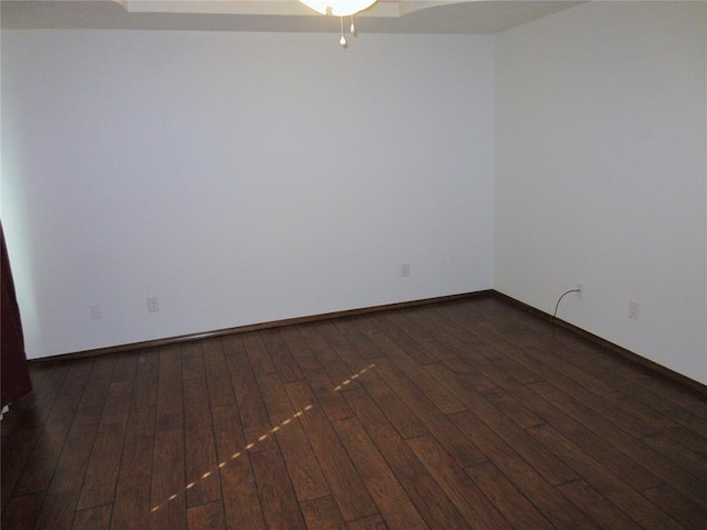 empty room with baseboards and hardwood / wood-style flooring