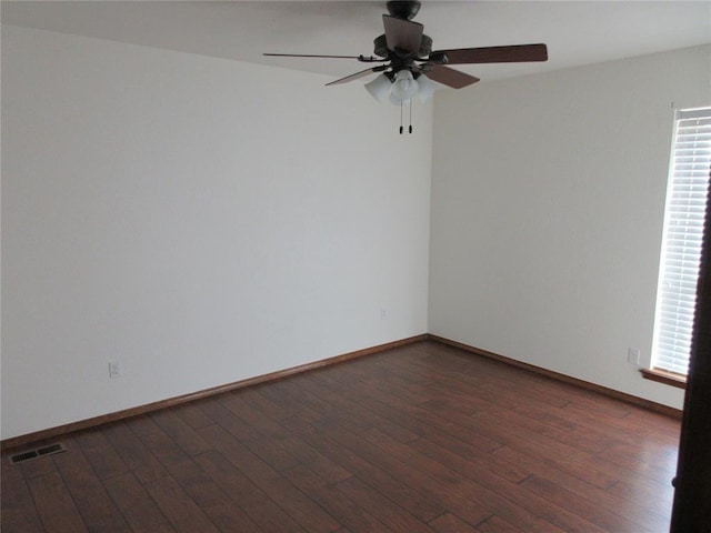 unfurnished room with visible vents, baseboards, dark wood finished floors, and a wealth of natural light