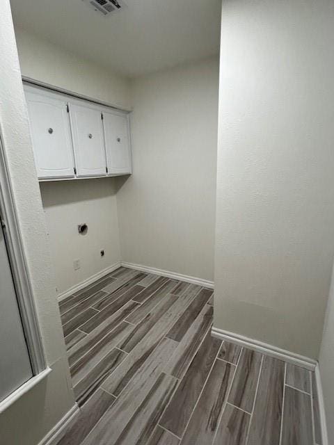 laundry room with baseboards, cabinet space, electric dryer hookup, and wood tiled floor