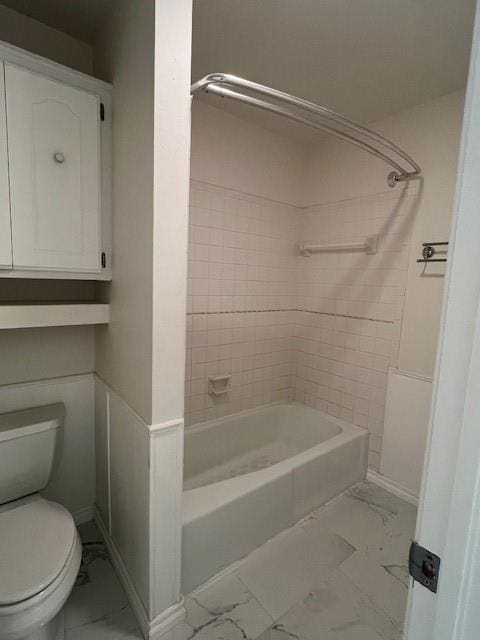 full bathroom with toilet, marble finish floor, baseboards, and tub / shower combination