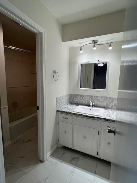 bathroom featuring marble finish floor, tasteful backsplash, tub / shower combination, and vanity