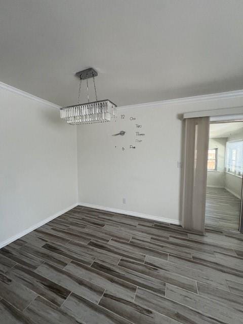 unfurnished dining area with wood tiled floor, ornamental molding, and baseboards