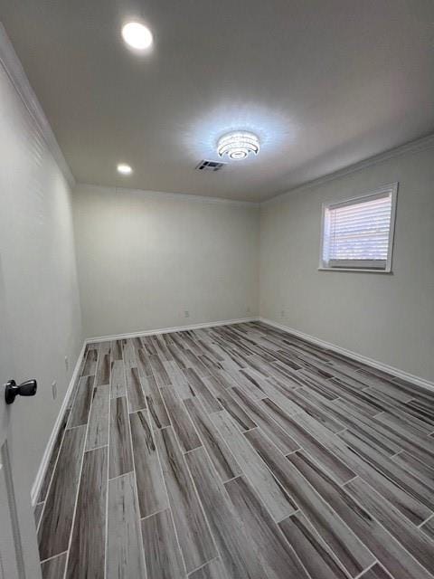 empty room with recessed lighting, wood finished floors, visible vents, baseboards, and ornamental molding