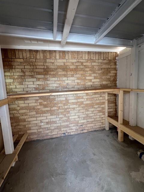 finished basement featuring brick wall