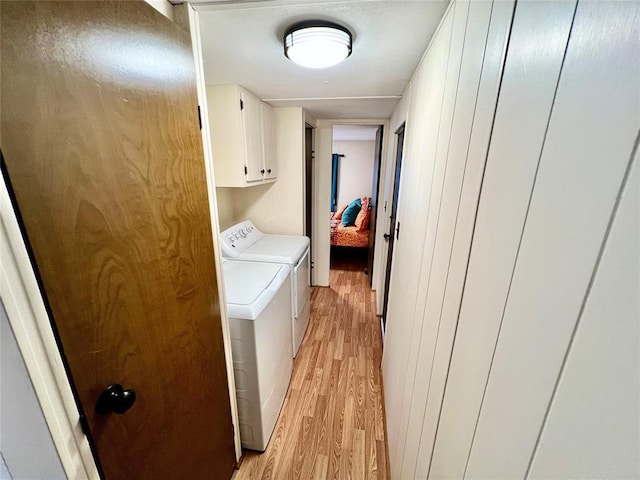 laundry room with cabinet space, independent washer and dryer, and light wood finished floors