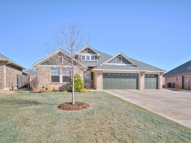 craftsman-style house with brick siding, an attached garage, cooling unit, driveway, and a front lawn