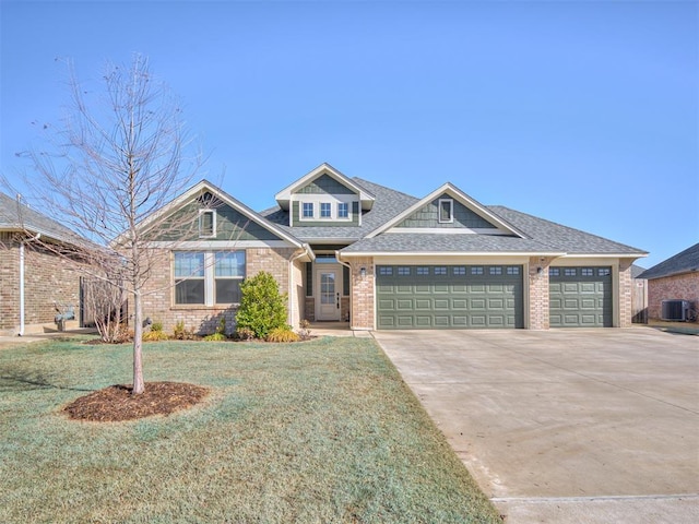 craftsman inspired home with brick siding, concrete driveway, an attached garage, a front yard, and central AC