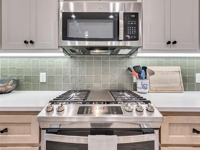 kitchen featuring stainless steel appliances, light countertops, and decorative backsplash