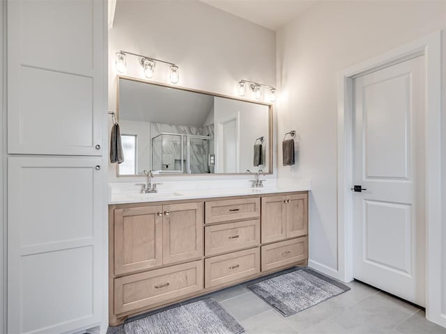 full bathroom featuring a stall shower, tile patterned flooring, a sink, and double vanity