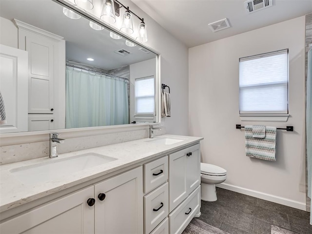 bathroom featuring toilet, baseboards, visible vents, and a sink