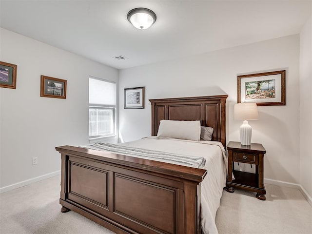 bedroom with visible vents, light carpet, and baseboards