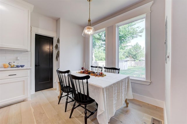 dining space with visible vents, light wood-style flooring, and baseboards