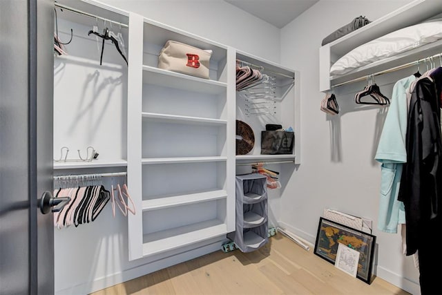 walk in closet with wood finished floors