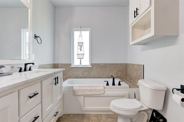 bathroom featuring toilet, a bath, and vanity