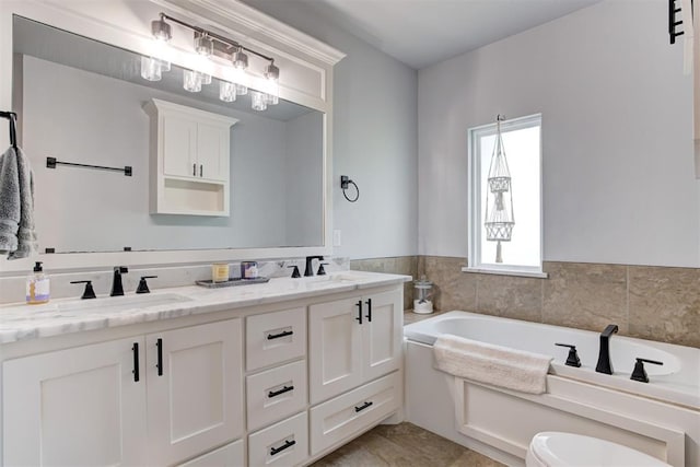 bathroom featuring a garden tub, double vanity, and a sink