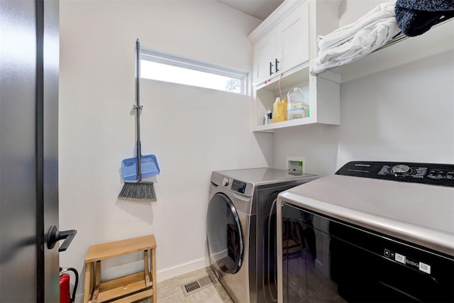 clothes washing area featuring cabinet space, independent washer and dryer, visible vents, and baseboards