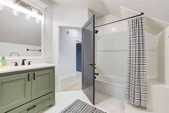 full bathroom with shower / tub combo, vaulted ceiling, and vanity