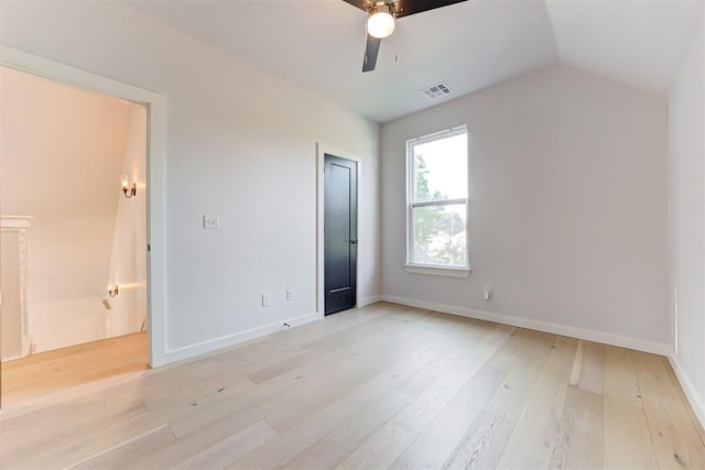 unfurnished bedroom featuring ceiling fan, visible vents, baseboards, vaulted ceiling, and light wood finished floors